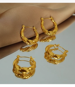 Vue macro de boucles d'oreilles créoles torsadées plaquées or avec reflet élégant