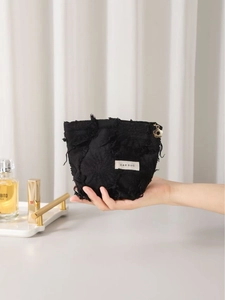 Minimalist black fringe cotton linen cosmetic bag with floral gold zipper held in hand