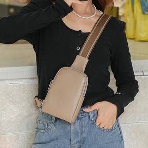 Sac de poitrine minimaliste en cuir kaki avec sangle en toile, porté par un mannequin