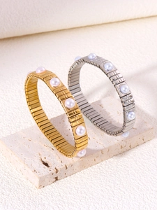 Dettaglio dei bracciali elastici in oro e argento con intarsio di perle d'acqua dolce