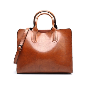 Detailed shot of brown leather handbag featuring fine stitching and adjustable strap