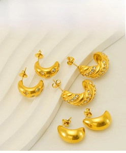 Macro shot of 18k gold plated stainless steel star and twisted diamond hoop earrings
