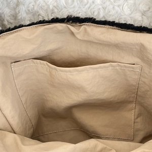 Detail view of the dog plush tote bag interior featuring a beige lining and open pocket