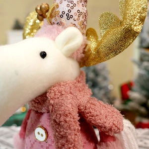 Detailed close-up of pink sequined Christmas reindeer plush with golden antlers and soft scarf