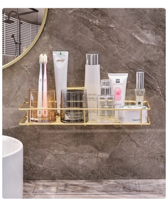 Detail of gold wall-mounted bathroom rack with drainage design on marble wall