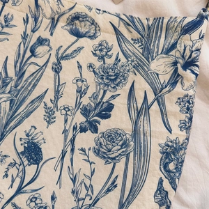Macro detail of vintage blue floral patterns on textured cotton fabric shoulder bag