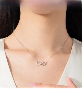 Macro detail of S925 sterling silver infinity pendant with small diamonds on a model neck