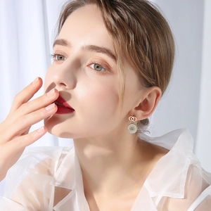 Close-up of golden double-circle shell earrings on model with elegant glossy finish