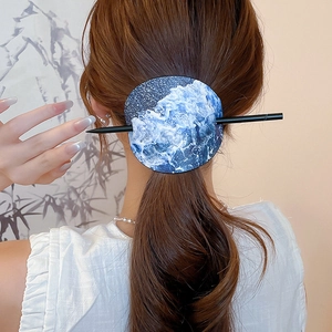 Detail einer Haarspange im chinesischen Stil mit blauem Wellenmuster auf Lederanhänger
