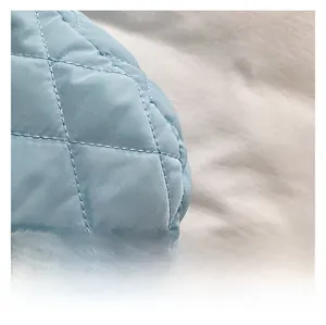 Macro shot of blue quilted space cotton fabric with rhombus stitching on a tote bag