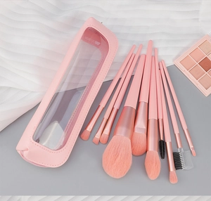 Macro detail of soft pink makeup brushes with synthetic bristles and matching leather pouch