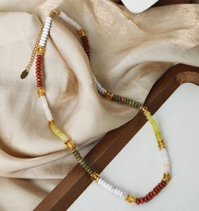 Macro detail of Bohemian beaded necklace with colorful stones and gold extension chain