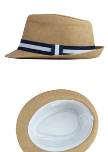 Detail view of khaki paper straw fedora with blue striped band and internal 100% paper tag