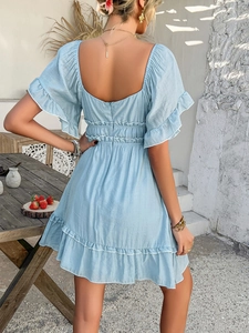 Detail view of the back of a light blue mini dress with smocked waist and ruffles