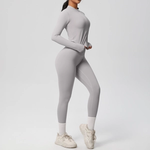 Détail ensemble de yoga gris clair avec manches passe-pouce et legging taille haute