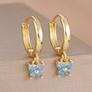 Détail de boucles d'oreilles papillon dorées serties de zircons bleus brillants