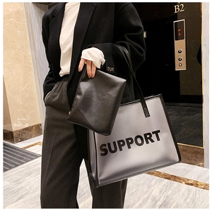 Close-up of semi-transparent grey PVC tote bag with black inner pouch and Support text