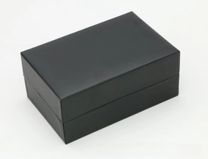 Detail shot of a black rectangle faux leather watch box with a simple flip-top closure