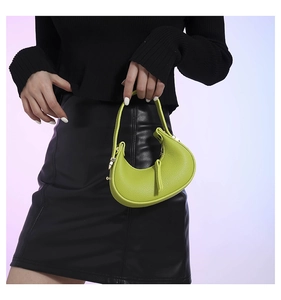 Macro shot of lime green leather texture on crescent bag with gold hardware detail