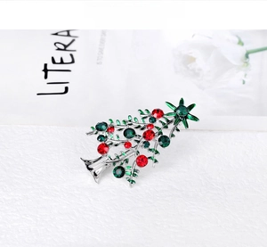 Detailed view of rhinestone-encrusted Christmas tree brooch with festive red and green gems
