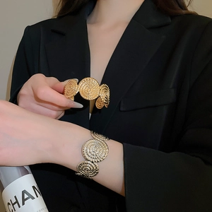 Detailed view of vintage gold and silver embossed bangles with spiral texture disks