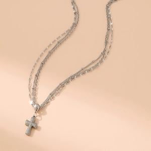 Detailsicht der mehrlagigen silbernen Edelstahlkette mit Kreuz und Herzanhängern