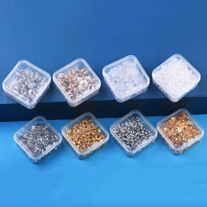 Macro detail of assorted earring backings in gold, silver, and clear silicone boxes