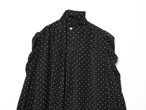 Dettaglio del vestito a pois neri con collo a fiocco e maniche lunghe con elastico
