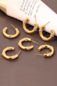 Detail of C-shaped gold bamboo earrings with sparkling rhinestone crystals in a group view