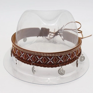 Detail of bohemian brown hat band with woven patterns and vintage silver coin charms
