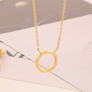 Detail of interlocking golden circle pendants on a minimalist stainless steel chain