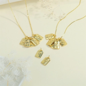 Golden square alphabet pendant necklace featuring engraved letters on a minimalist chain