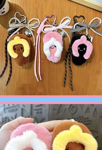 Close-up detail of cute plush flip-flop keychain charms with colorful bows and pearls