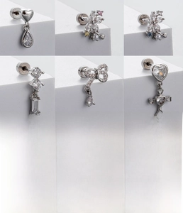 Detailed macro view of silver titanium steel earrings with heart, flower, and bow designs