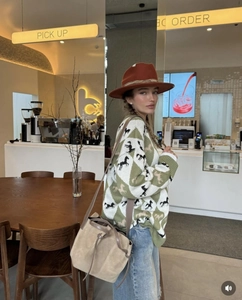 Detail of horse jacquard knit sweater with wide brim fedora and suede bucket bag