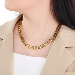 Classic golden Cuban link necklace on model wearing beige blazer with premium metallic shine