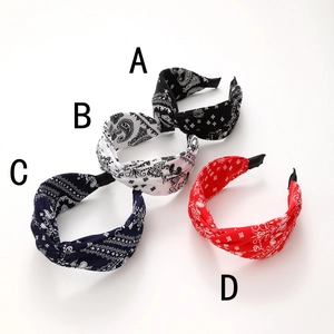 Wide paisley printed knot headbands in black, white, navy, and red on white background