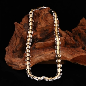 Collier chaîne dragon bicolore or et argent pour homme sur socle en bois texturé