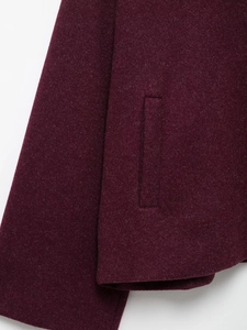 Detailed close-up of side pocket and sewing on dark red wool blend oversized coat