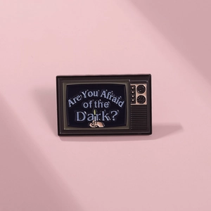 Detail of vintage TV enamel pin featuring 'Are You Afraid of the Dark?' artwork and match