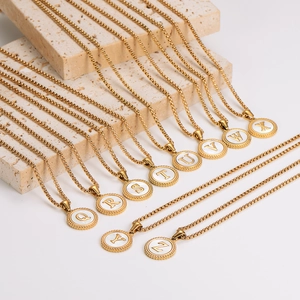 Gold stainless steel round pendant necklace with white shell inlay and gold letter charms