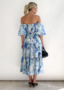 Rear view of floral off-shoulder maxi dress with puff sleeves and tiered skirt details