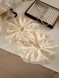 Detailed view of cream lace scrunchies with pleated fabric and small ribbon bows