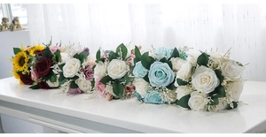 Detail view of six bridal bouquets with roses and sunflowers for wedding photography