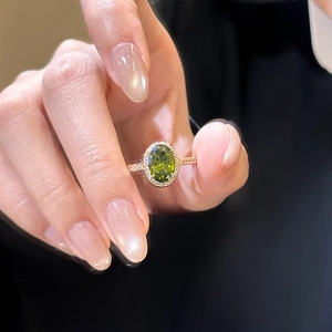 Macro shot of 18k gold-plated ring featuring an oval green zircon and pavé side stones