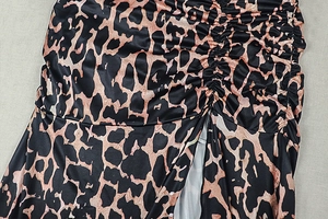 Detail eines eleganten Leopardenkleids mit Raffungen und modischem Seitenschlitz