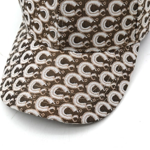 Macro shot of brown jacquard baseball cap featuring classic vintage C-letter pattern fabric