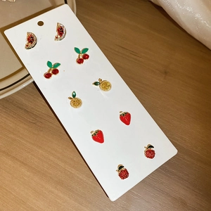 Detailed view of six pairs of fruit-themed rhinestone stud earrings on card
