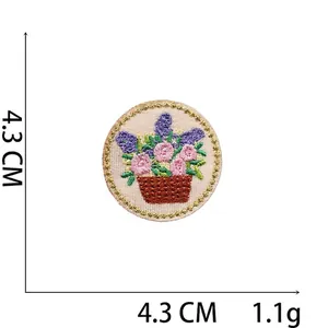Macro detail of a 4.3cm floral basket embroidery patch with gold thread edging