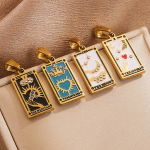 Vintage gold tarot card pendants with colorful enamel and zircon crystals set on beige fabric
